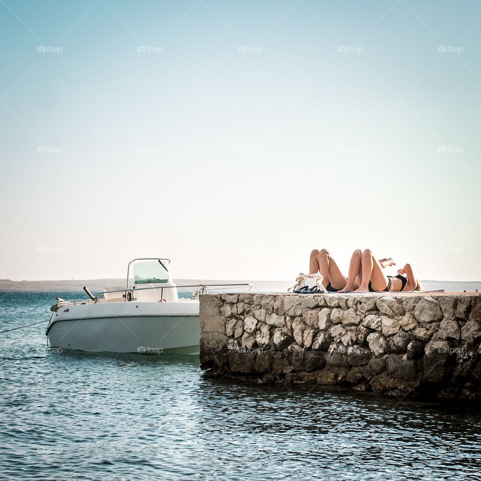 Couple resting on a pier by the sea