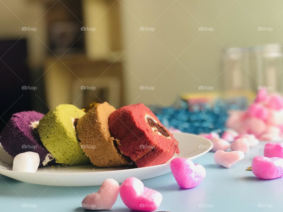 Delicious and colourful cake pieces on plate with love hearts 