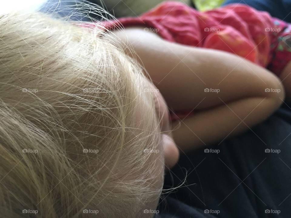 Sleeping child wearing a pink dress.