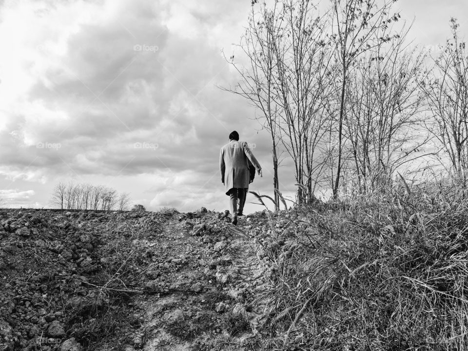 black and white photo of a lonely man in a field