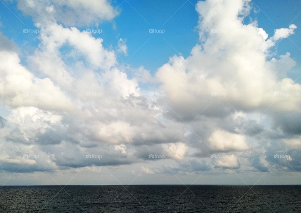 Cloudscape on the sea, cumulus clouds formation towards cumulusnimbus.