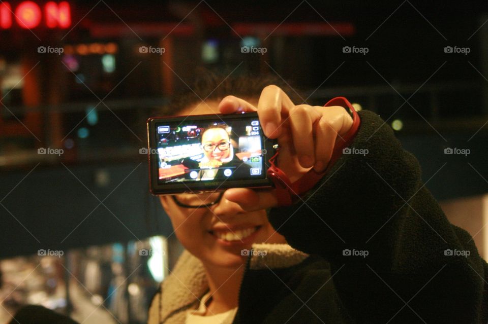 Young man holding digital camera in hand