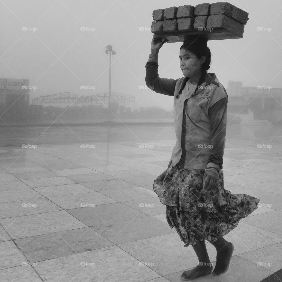 Child carrying bricks