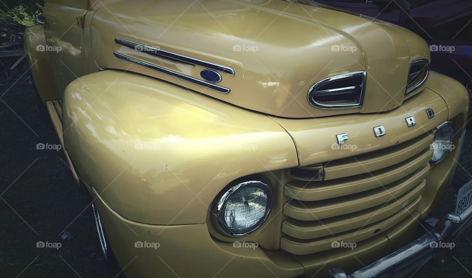 A front view of the hood and grill of a classic Ford truck