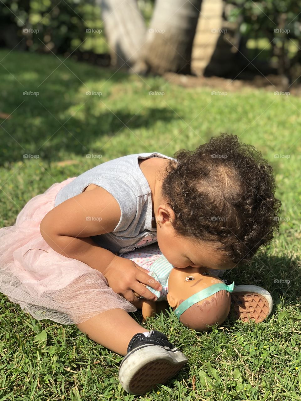 Baby kissing her doll 
