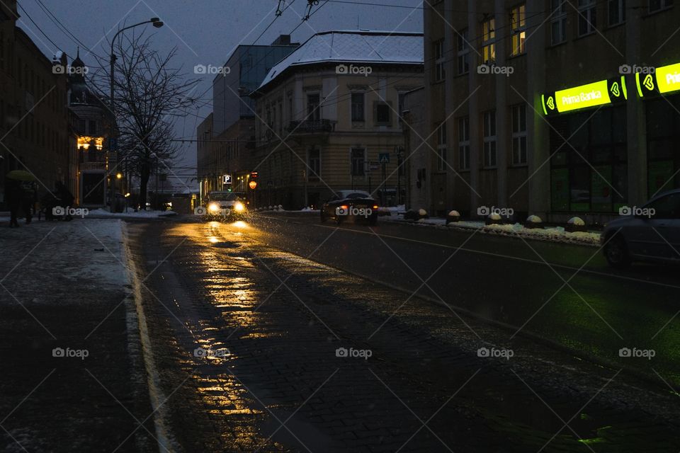 Street in the night with cars and snowy weather