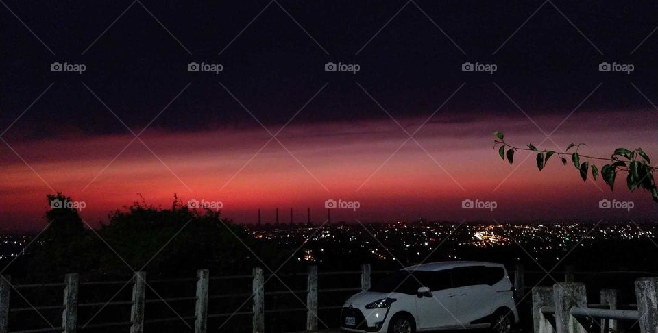 Light: natural vs artificial. looking the beautiful twilight and  nightscape from a hill.