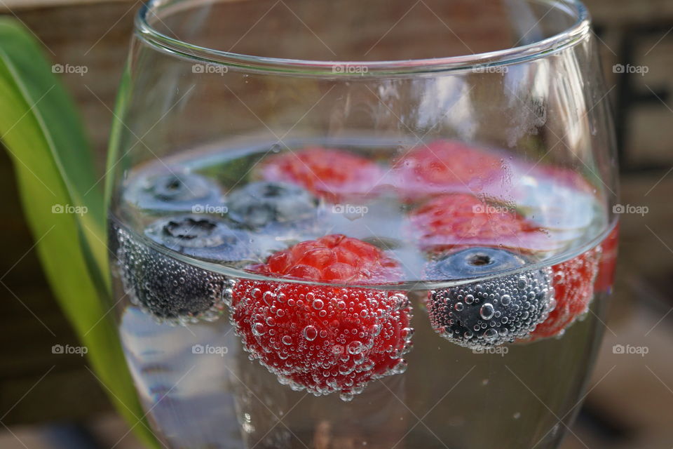 Blueberries and Raspberries fizzing in a glass 