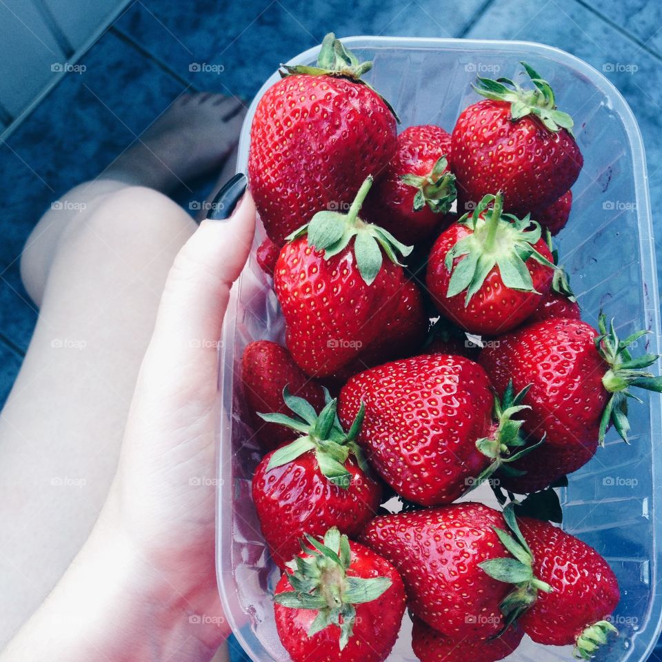 A person holding juicy strawberry