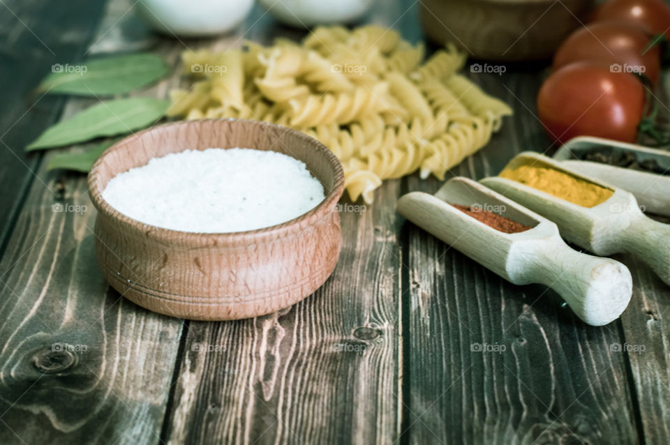 Raw pasta with ingredients and wooden accessories