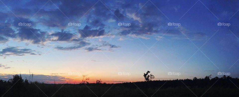Sunset view above a valley as storm clouds begin to form.