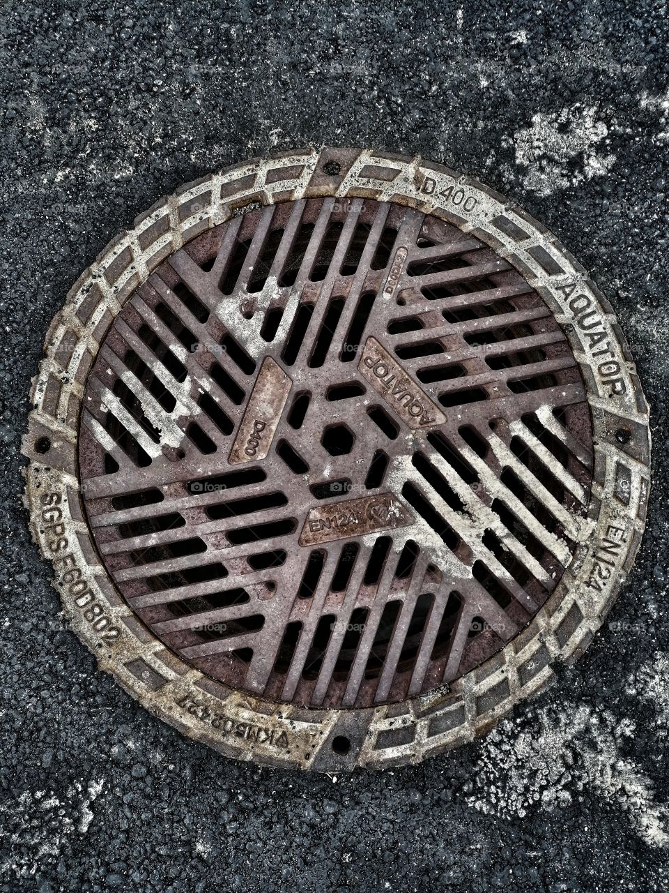 Old beautifully patinated manhole cover seen from above.