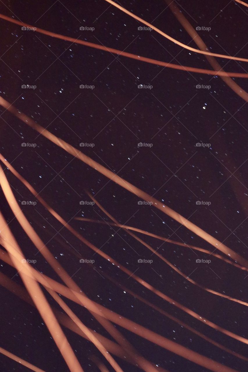 Firelight and sparks passing by the star filled sky