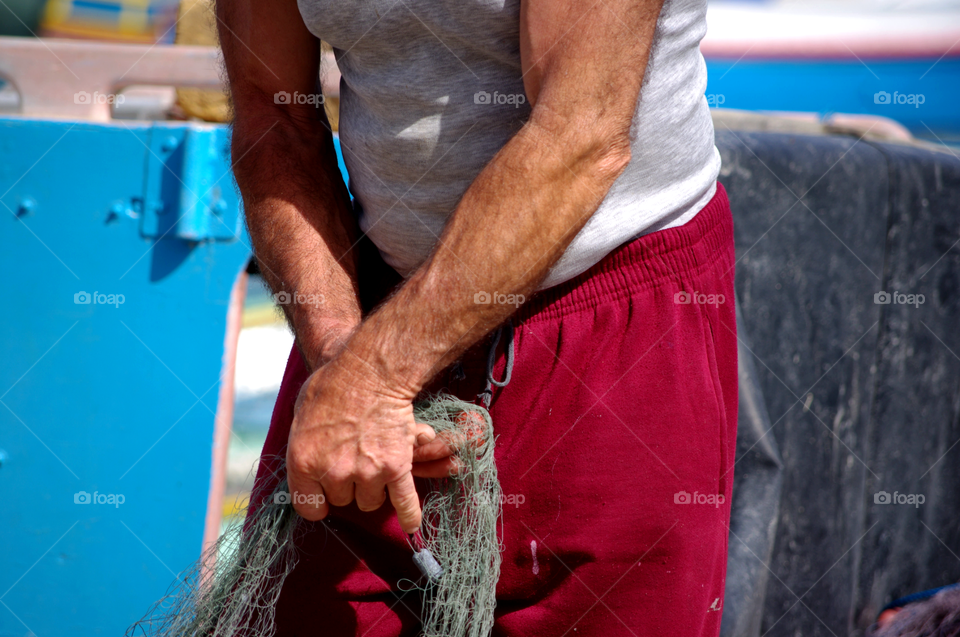 Fisherman's hand at work in marsaxlokk Malta