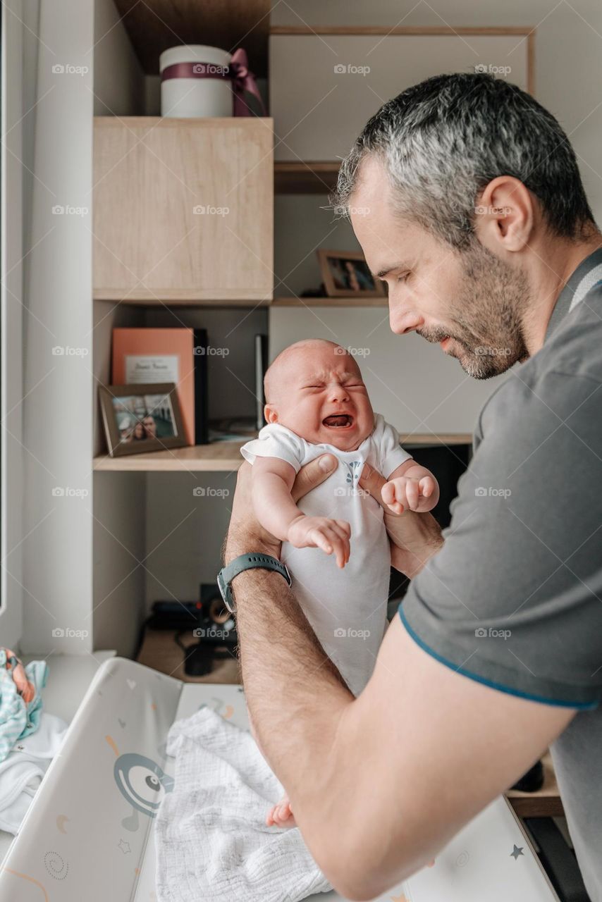 Father holding his crying baby son