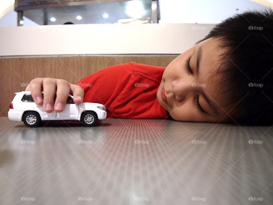 young boy playing with a toy car