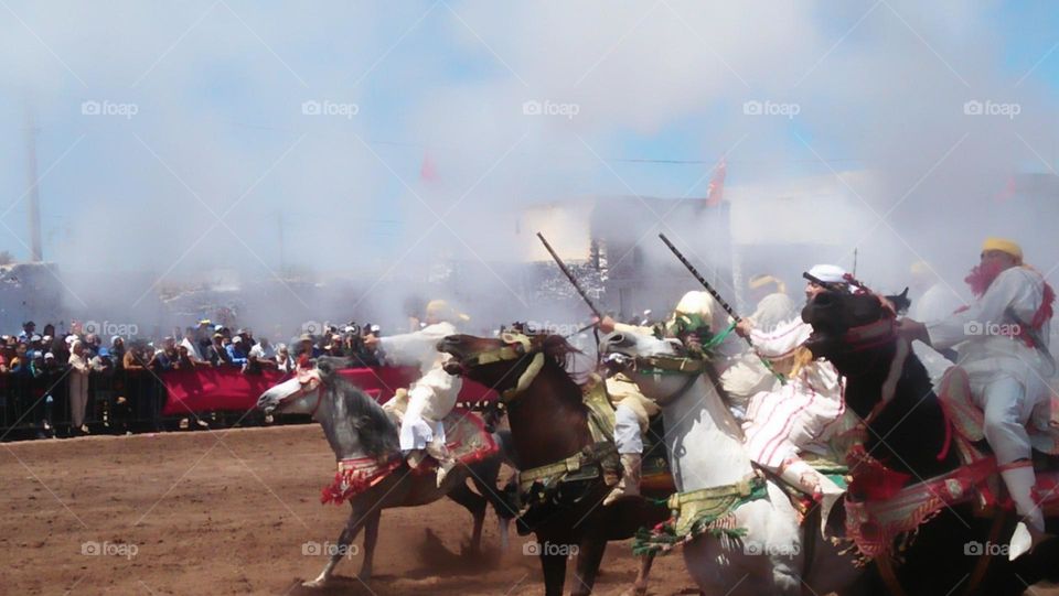 Horseback riders shoot from their guns