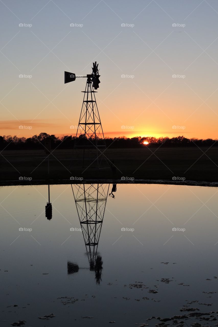 Silhouette of old antique windmill on rural farm