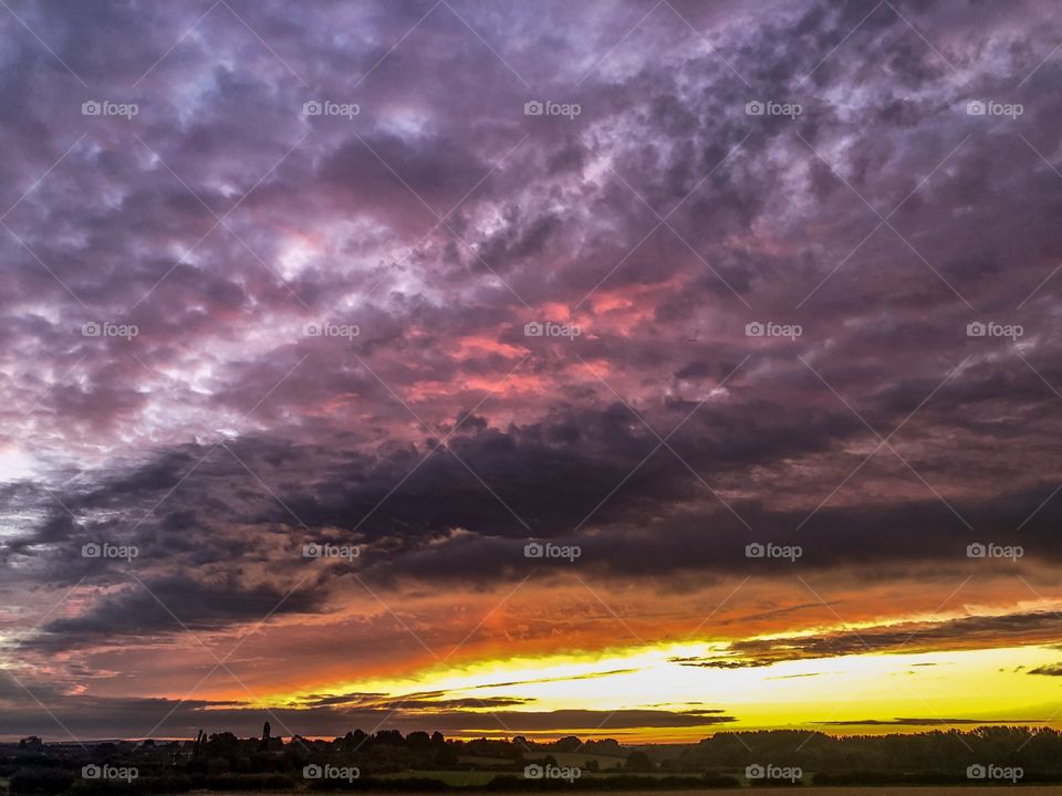 A dramatic sky over England gives off beautiful colours of orange pink and purple. 