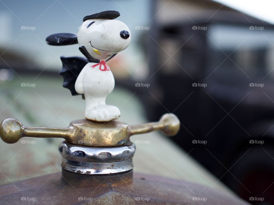 A Halloween Snoopy vampire hood ornament on an old truck