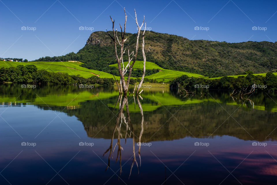 lake with clear still waters and a mountain background