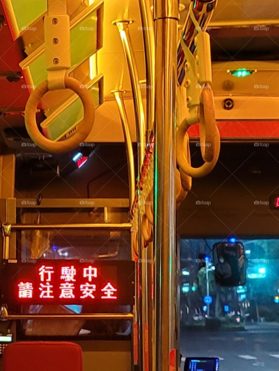 A retro-style bus with a warm yellow light interior. The marquee reads "Please pay attention to safety while driving" in Chinese