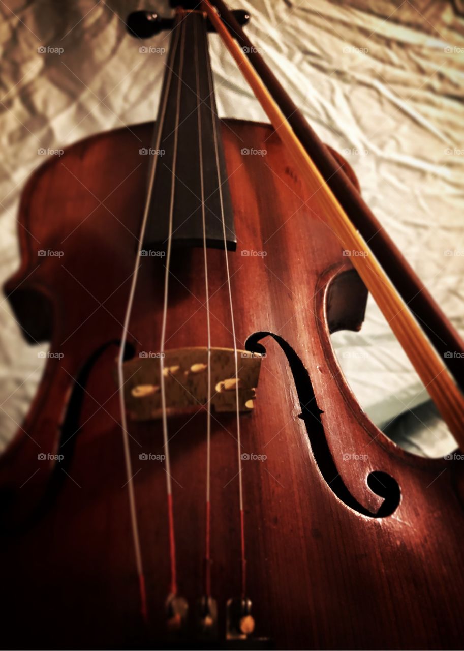 Old violin with bow on light background. Close up