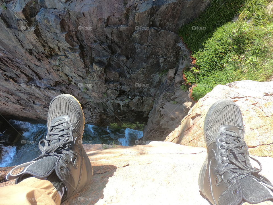 Looking down a cliff. Shoes and cliff 