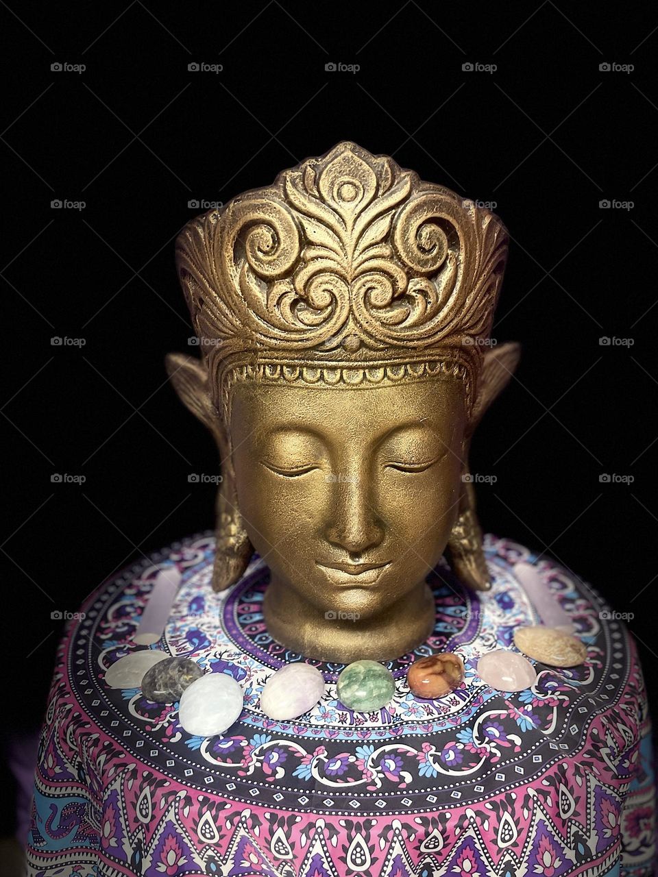 A Buddha meditating with crystals. 