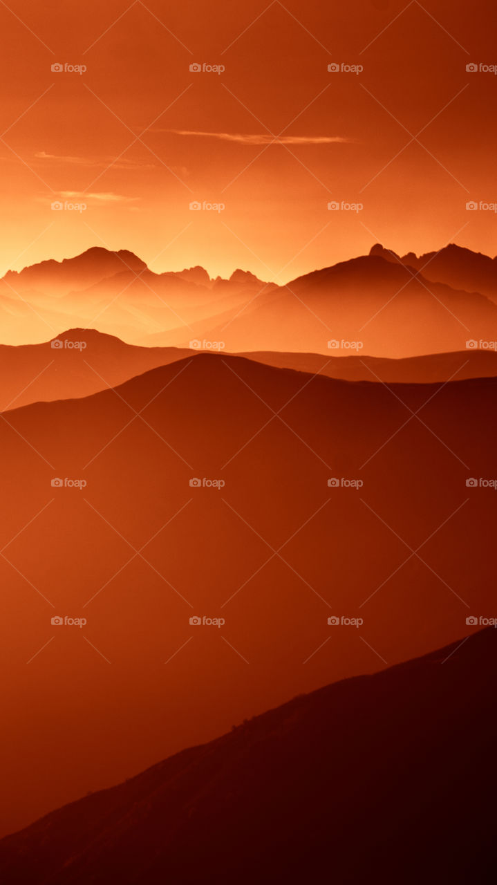 An inspiring red mountain landscape. Tatry mountains in Slovakia. A beautiful wallpaper for smartphone screen. Red abstract gradient with perspective.