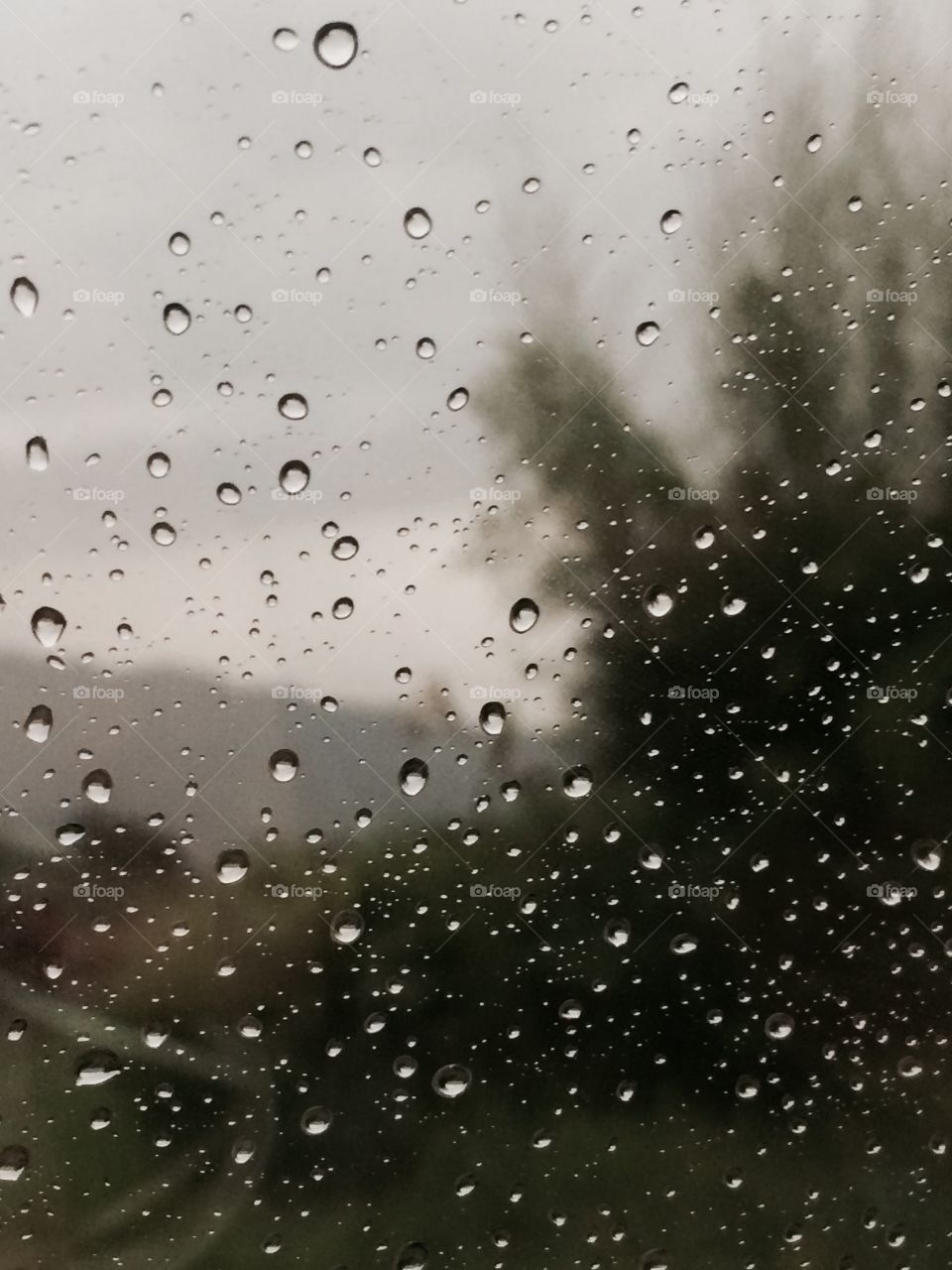 Raindrops on window with unfocused background