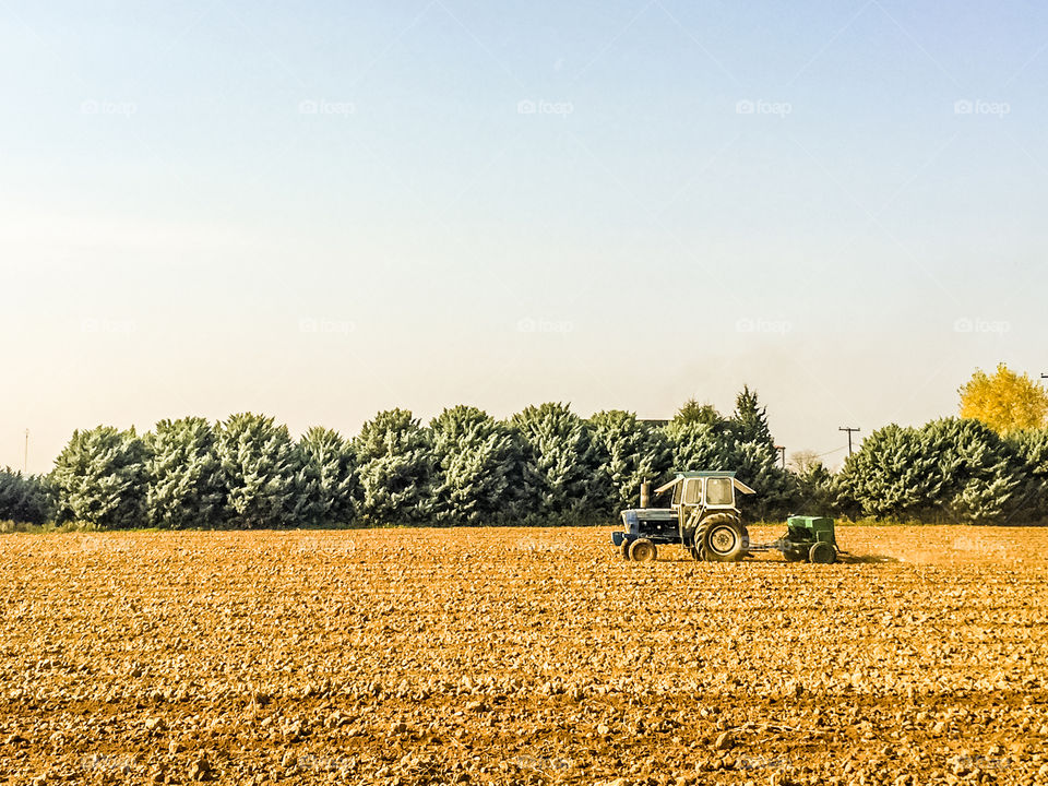 Tractor Ploughs Field In A Beautiful Rural Landscape
