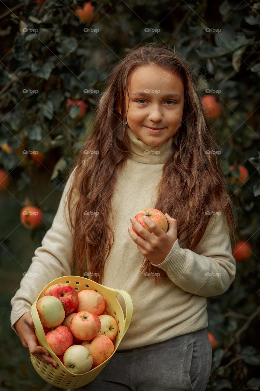 Long-haired girl with basket of apples