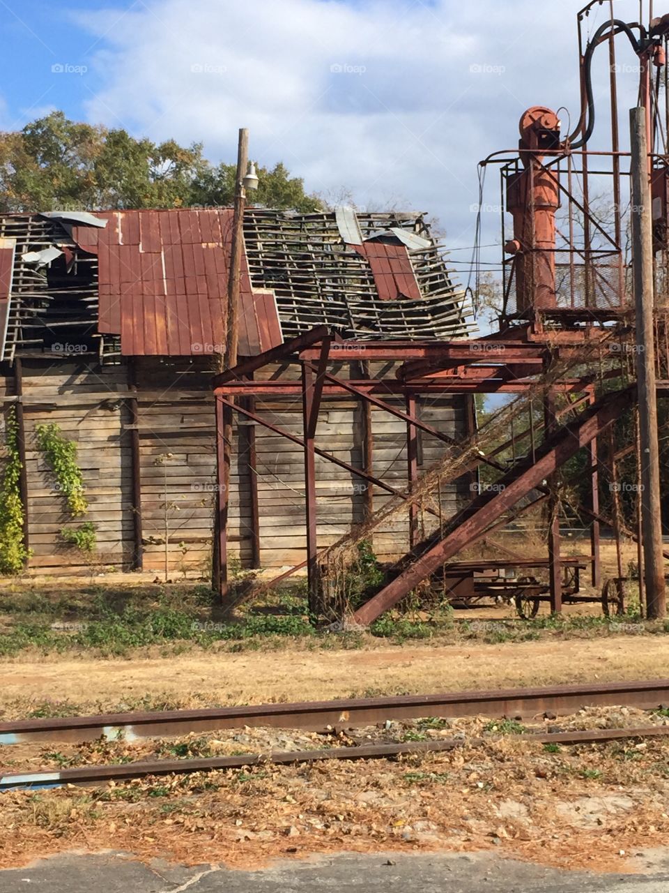 Old wooden structure with tin roof and falling down iron structure.