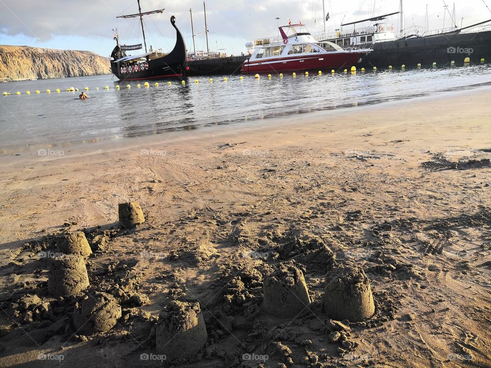 Boats, beach and sand castle