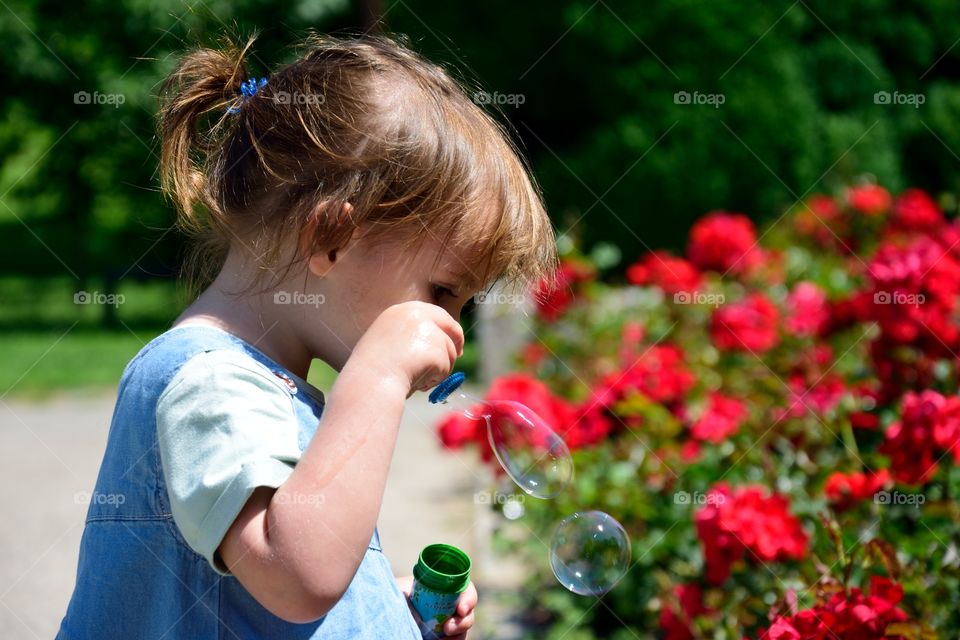 Little girl with ballons in garden