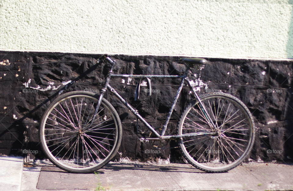 Black old bike near the old wall