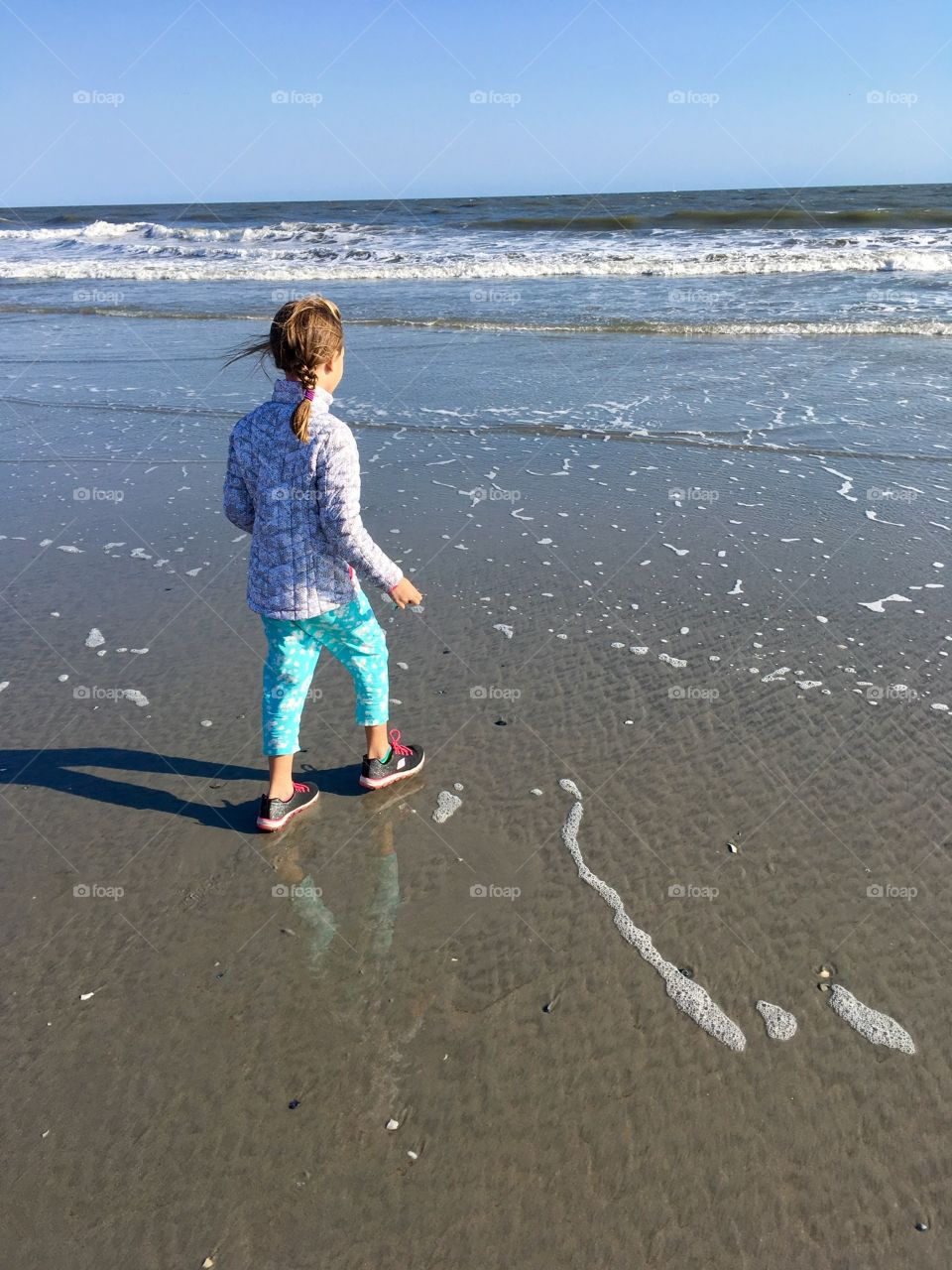 Girl walking on beautiful windy beach