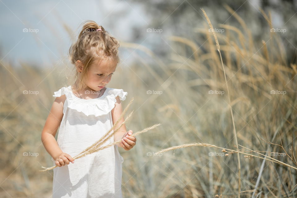 Two little sisters walking at cloudy summer day