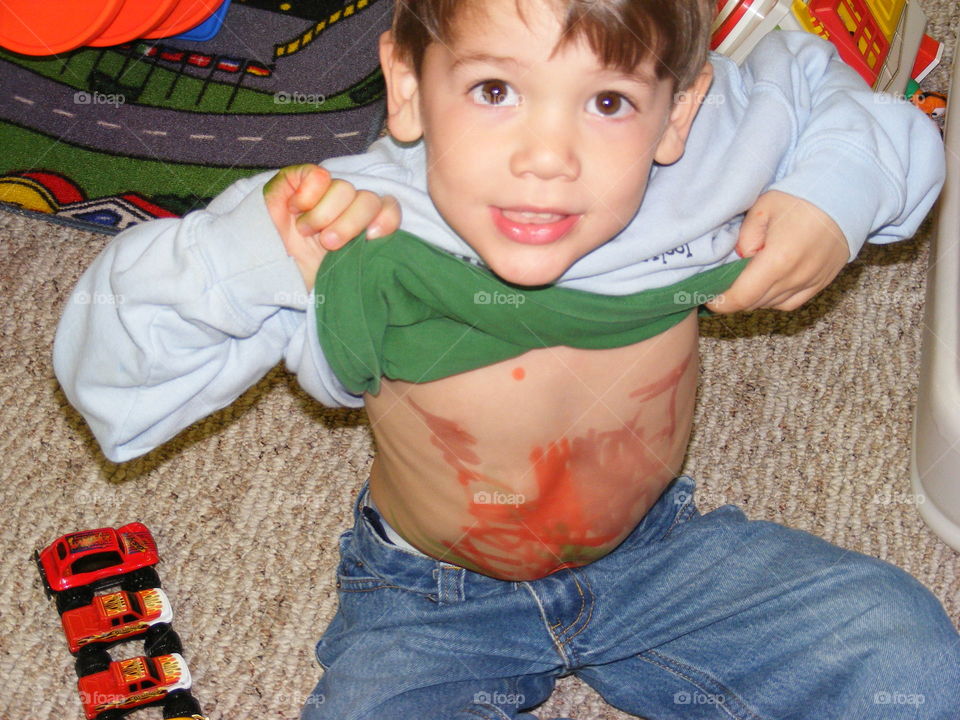Small boy showing messy stomach