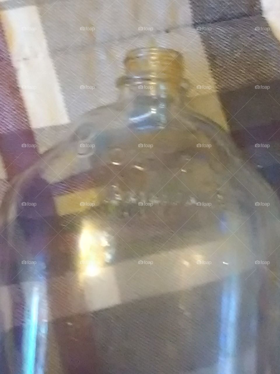 an antique glass Little Bo Peep ammonia bottle on a textured background