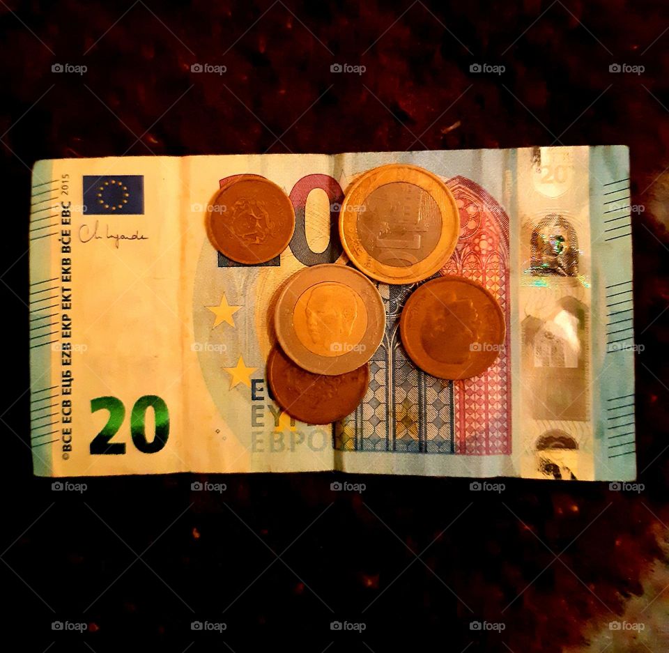 A 20 Euro banknote featuring vibrant colors and intricate details showcasing European architectural landmarks. The 10 and 5 Dirham coins are designed with Moroccan national symbols, reflecting the country’s rich architectural heritage.