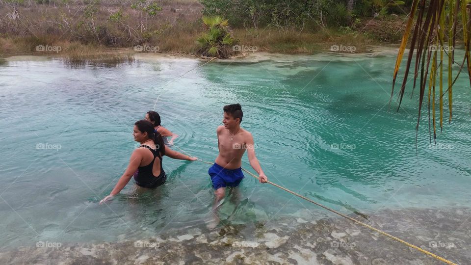 niños jugando en las aguas de laguna Bacalar en México