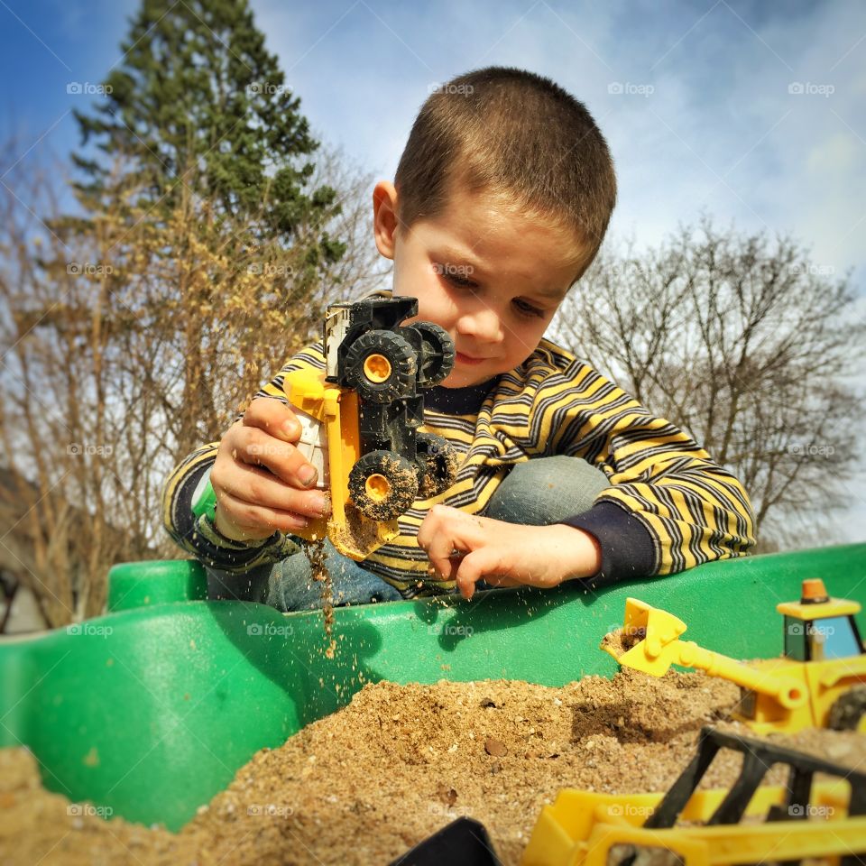 Boy playing with toy vehicles