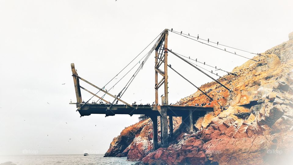 An abandoned bridge extended over the ocean.