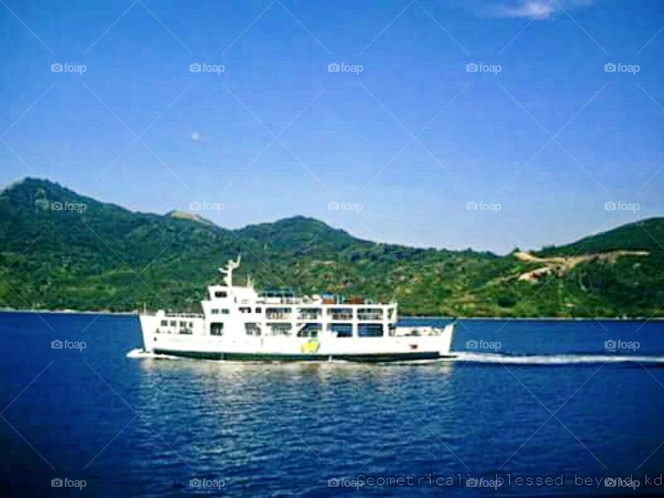 White ship navigating in a calm blue water with the stunning beauty of natural view.