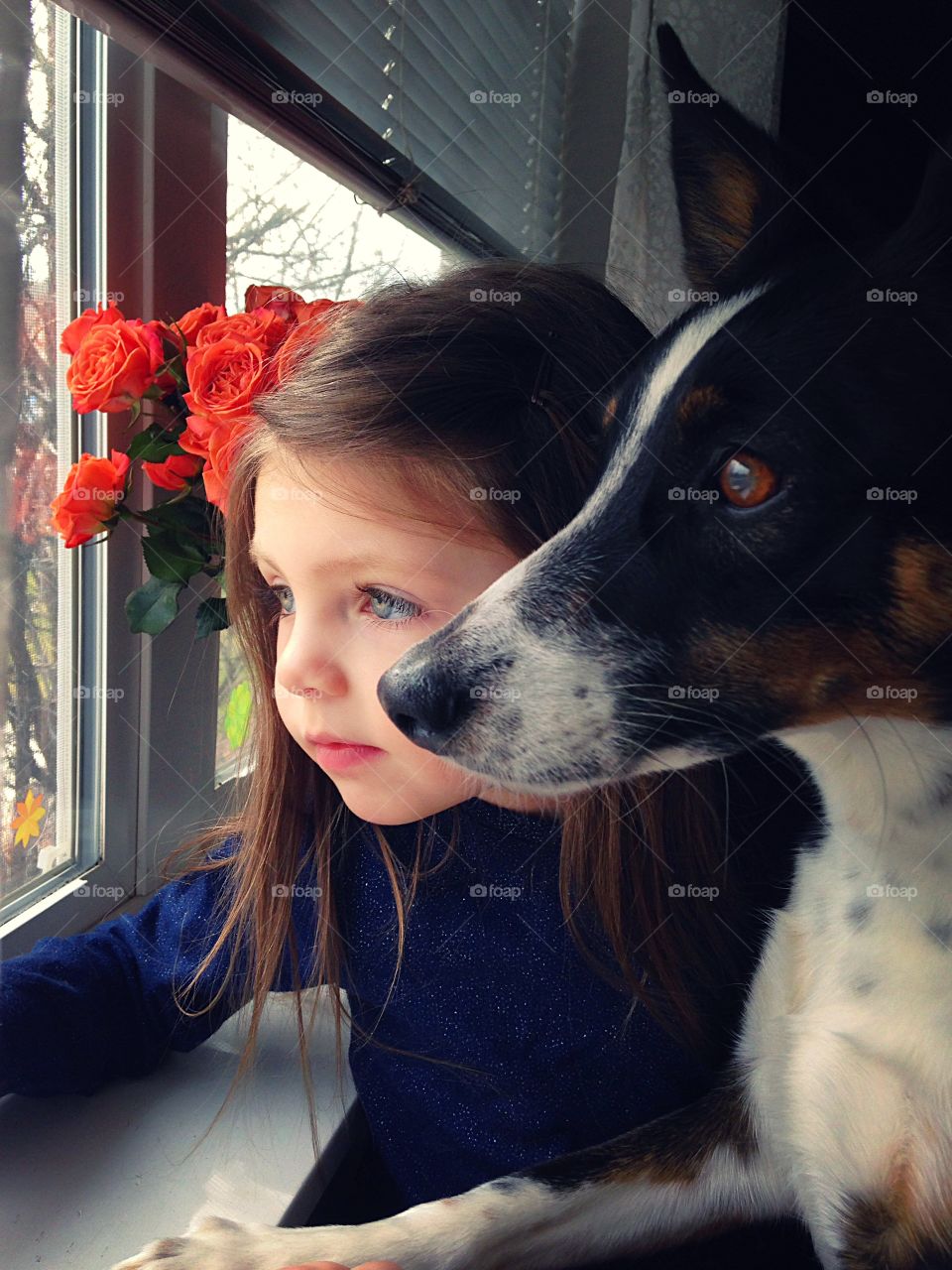 Little girl with dog near window