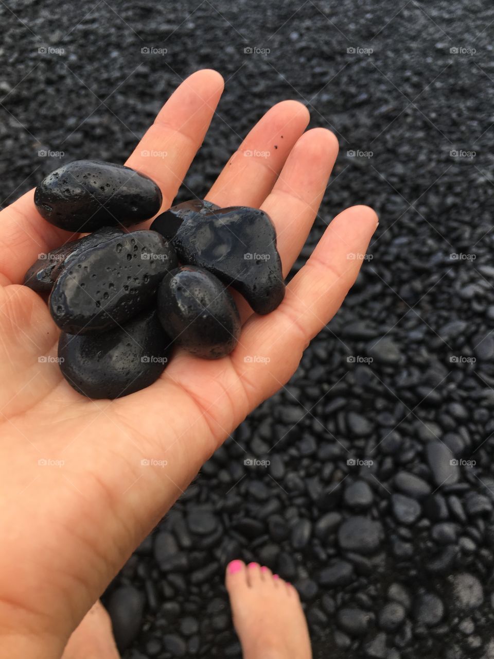 Woman carrying black rocks in hand
