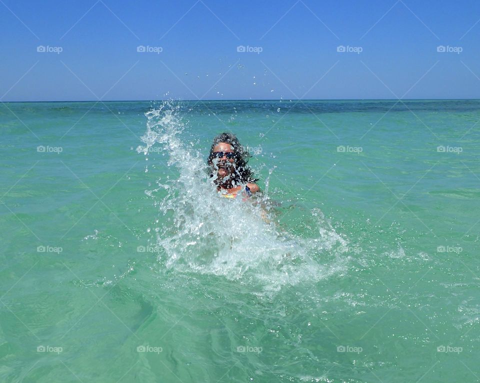 Glimmer of happiness splashing on turquoise waters having all the beach to oneself 