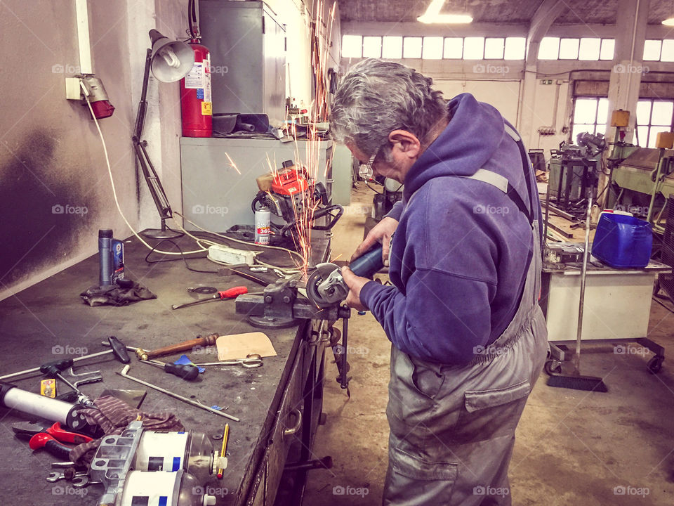 Machinist Craftsman, Working With Grinding Wheel Tool And Metal In The Workshop
